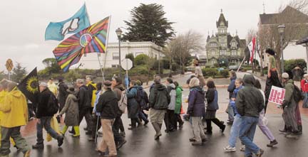 [marchers with peace flags on wet street, Carson Mansion in background]